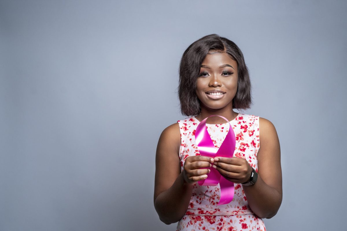 An African-American woman holding a ribbon - the concept of world cancer campaign support
